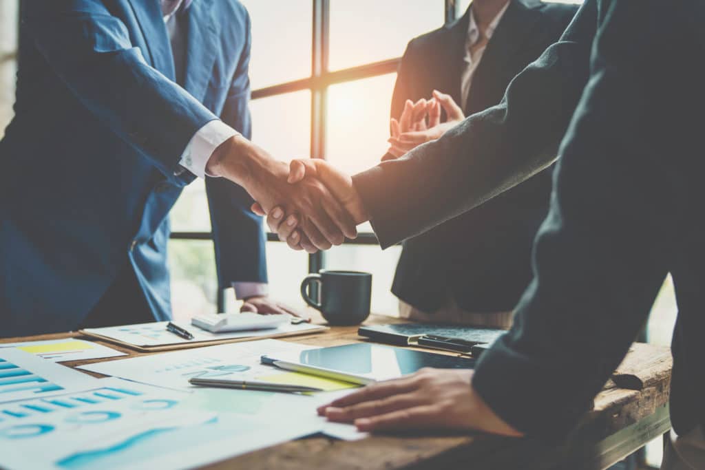 Business team shaking hands and clapping after a business deal